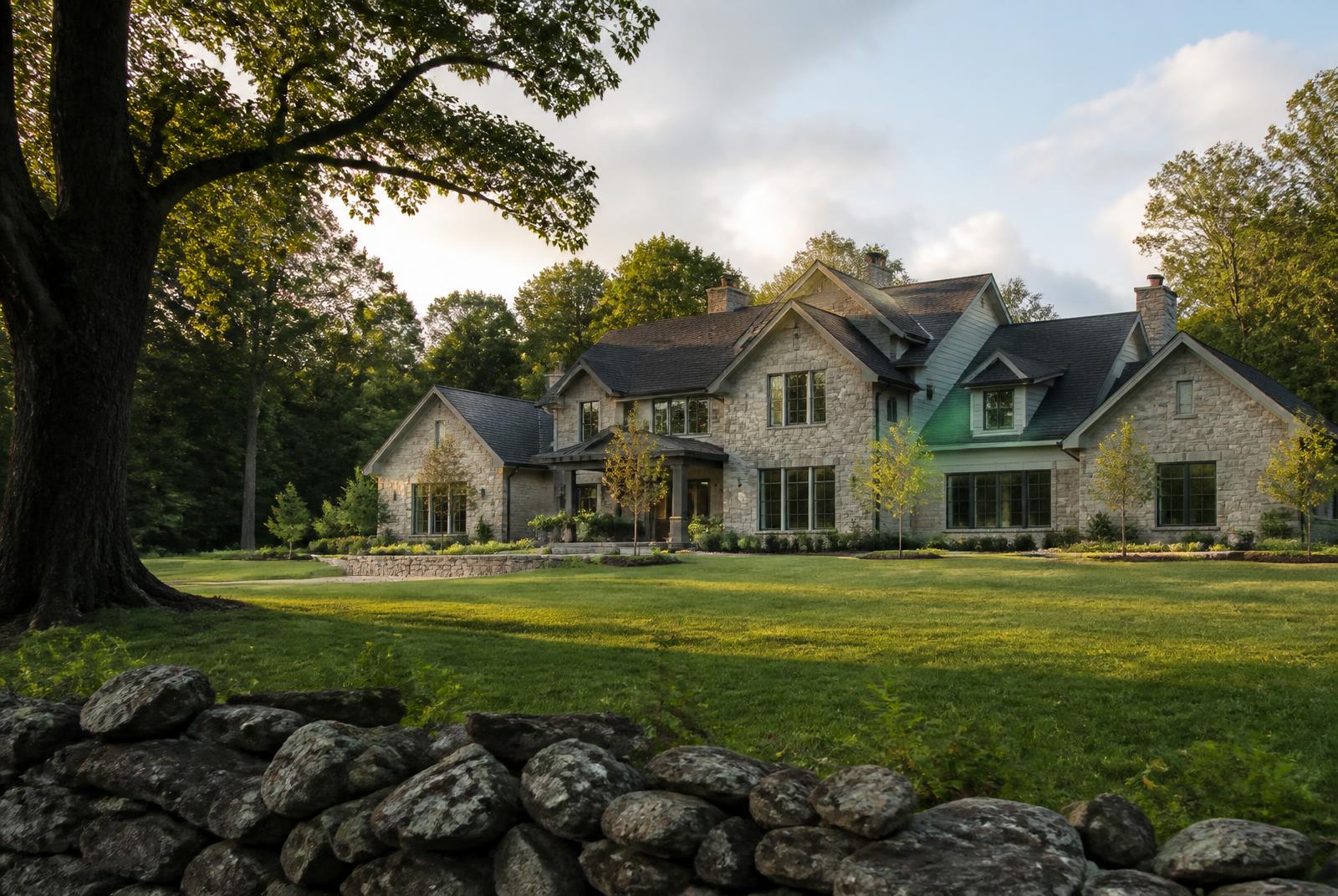 Stone-and-siding new home on a generous lot bordered by mature trees and open space
