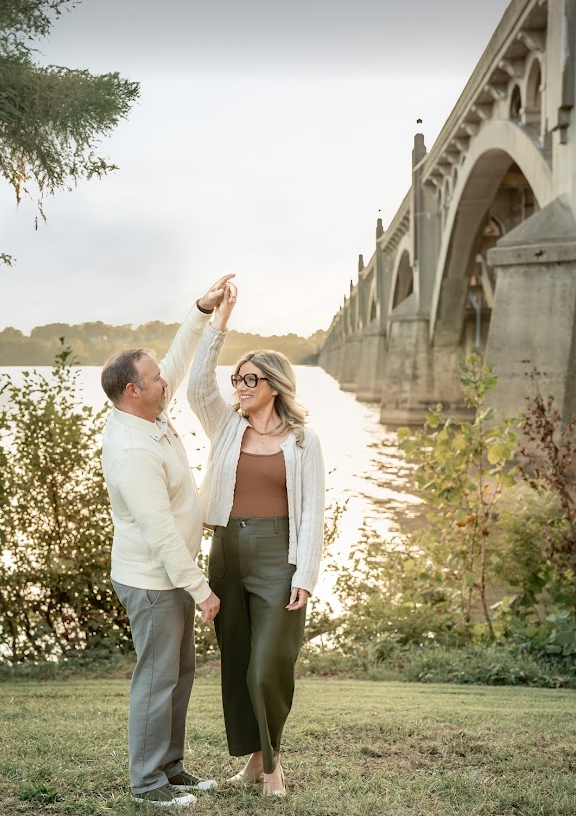 Corie Adams and her husband Matt dancing together by the river at sunset